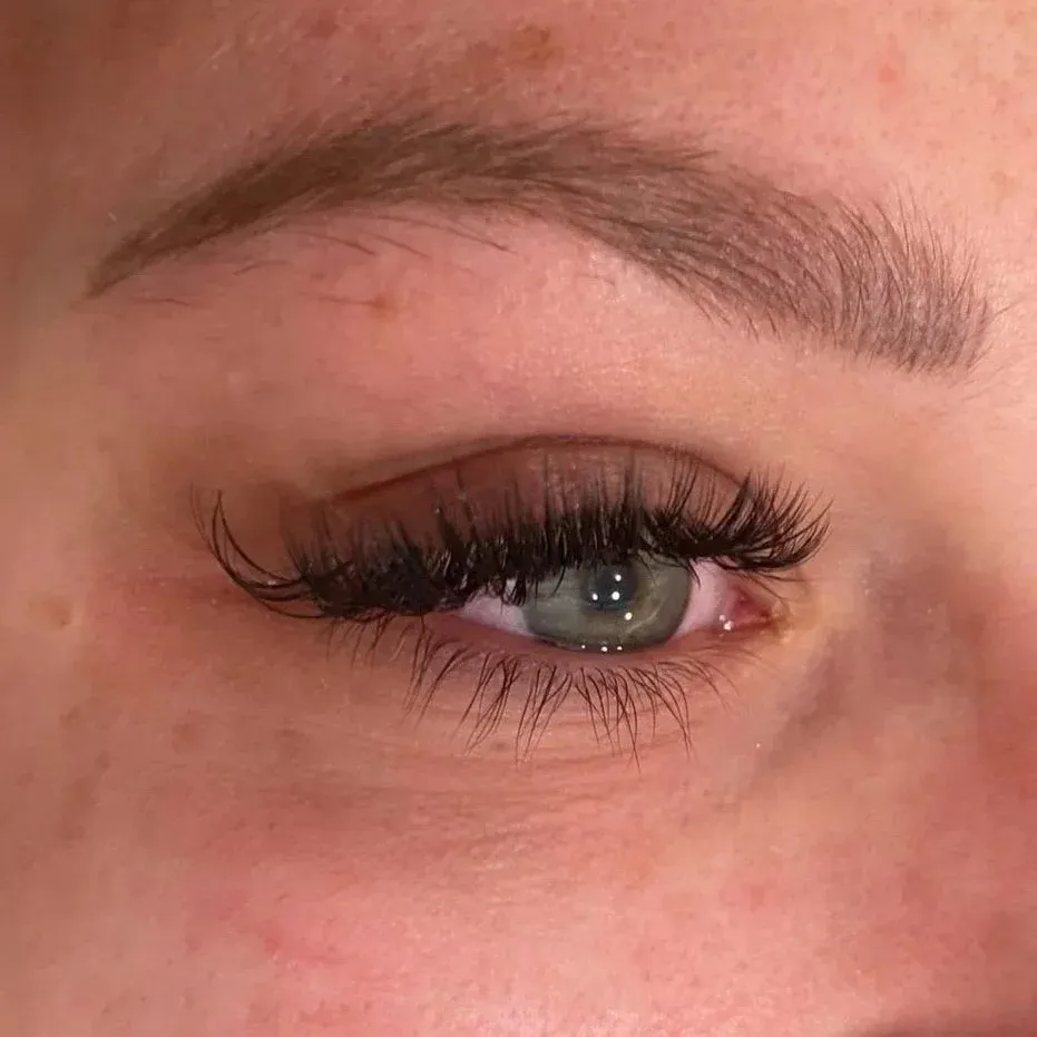 Close-up of a natural classic eyelash extension set on a green-eyed client